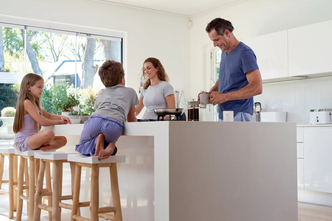 Familie beim professionellen Streichen in heller Küche - Beispiel für richtige Streichtechnik
