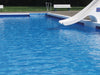 Blauer Swimmingpool mit weißer Rutsche - Beispiel für professionell beschichteten Betonpool mit Poolfarbe