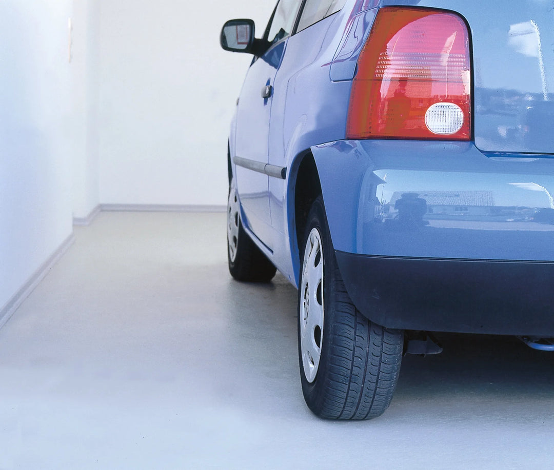 Blaues Auto in moderner Garage mit heller, beschichteter Bodenfläche - Beispiel für professionelle Garagenbodenbeschichtung