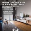 Modernes Wohnzimmer mit großem Fenster, hellem Holzboden, weißem TV-Ständer, Pflanzen und Sofa. Deutscher Text bewirbt plid Plid Universal Bodenkleber - stark haftend als geruchsneutral und stressfrei mit starker Haftung und dauerhafter Haltbarkeit für viele Böden.