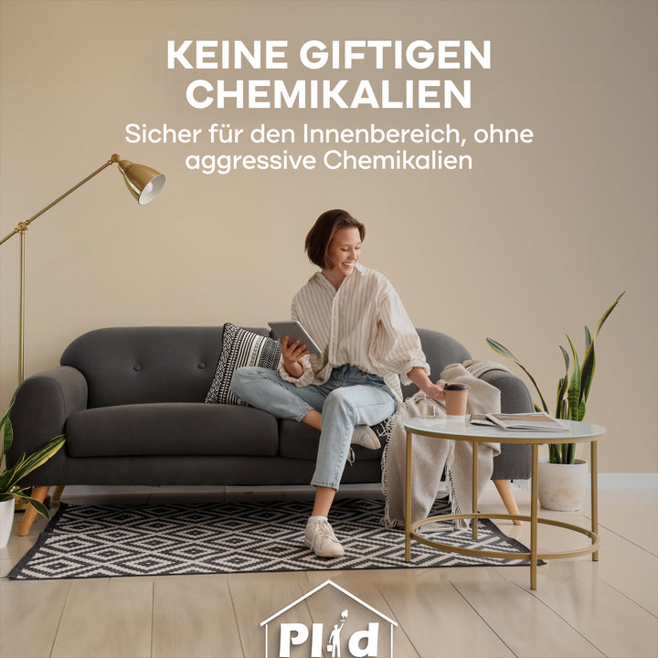 Eine lächelnde Frau sitzt auf einem grauen Sofa, in der Hand eine Tasse und ein Telefon. Text oben: Keine giftigen Chemikalien. plid Rauhfaser Reparatur-Spachtel - sicher für Innenräume, frei von aggressiven Chemikalien.