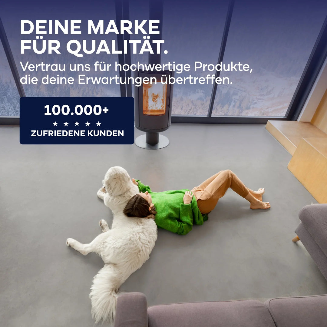 Eine Person in einem grünen Pullover entspannt sich auf dem Boden mit einem großen weißen Hund in einem modernen Wohnzimmer. Deutsch: plid Flüssigkunststoff Bodenbeschichtung für Innen &amp; Außen - über 100.000 zufriedene Kunden und spezielle Fußbodenbeschichtung.