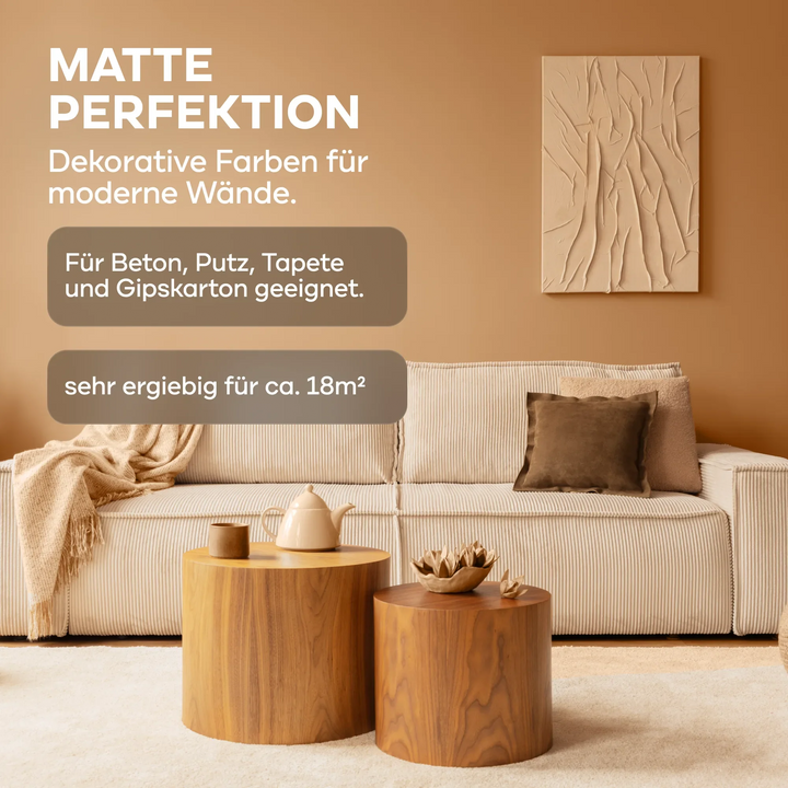 Beiges Wohnzimmer mit heller Couch, braunen Kissen, runden Holztischen und abstrakter Kunst. Die plid DesignColour Innenfarbe - Emissionsarm &amp; Geruchsneutral ist matt, reicht für ca. 18 m² und eignet sich für verschiedene Oberflächen.