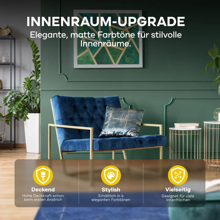 Ein modernes Wohnzimmer mit einer dunkelgrünen Wand in plid DesignColour Innenfarbe - Emissionsarm &amp; Geruchsneutral, blauem Samtsessel, gemusterten Kissen, goldenen Akzenten, Pflanzen und Regalen. Matte Töne sind vielseitig und emissionsarm für stilvolle Innenräume.
