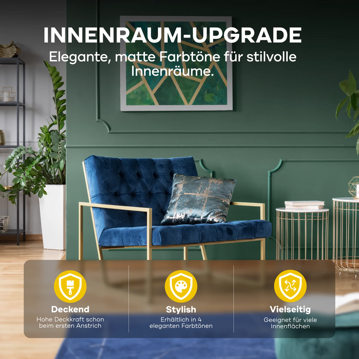 Ein modernes Wohnzimmer mit einer dunkelgrünen Wand in plid DesignColour Innenfarbe - Emissionsarm &amp; Geruchsneutral, blauem Samtsessel, gemusterten Kissen, goldenen Akzenten, Pflanzen und Regalen. Matte Töne sind vielseitig und emissionsarm für stilvolle Innenräume.