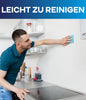 Ein Mann im blaugrünen Hemd wischt mit einem blauen Tuch eine mit plid Latexfarbe scheuerbeständig & hochdeckend innen gestrichene weiße Küchenwand ab. Darüber steht "LEICHT ZU REINIGEN" geschrieben. Die moderne Küche wirkt aufgeräumt.