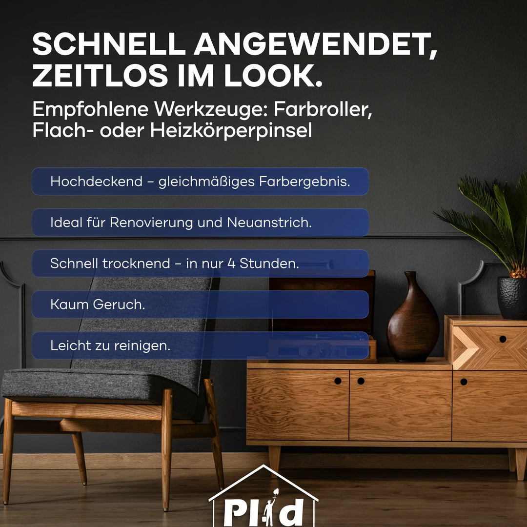 Modernes Wohnzimmer mit grauer Wand, Holzmöbeln, Stuhl und Pflanze. Die plid DesignColour Innenfarbe - Emissionsarm &amp; Geruchsneutral ist zeitlos, hochdeckend, schnell trocknend und lässt sich leicht reinigen.