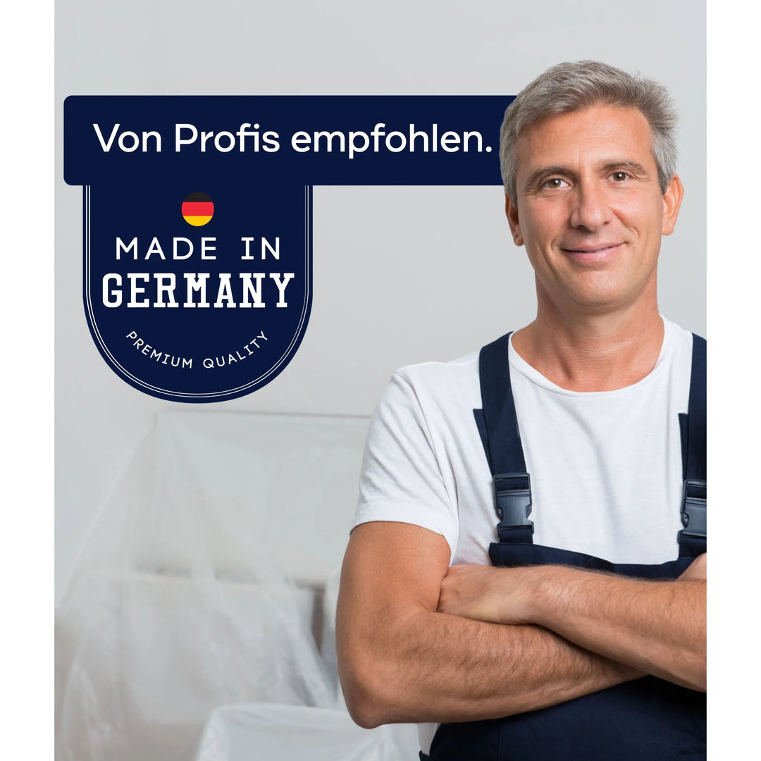 Ein lächelnder Mann in Latzhose steht mit verschränkten Armen neben einem Schild mit der Aufschrift "Von Profis empfohlen. Made in Germany. Premium Quality" und einer deutschen Flagge - ideal für PLID Epoxidharz mit Härter von plid, perfekt für River Table Projekte und mehr.