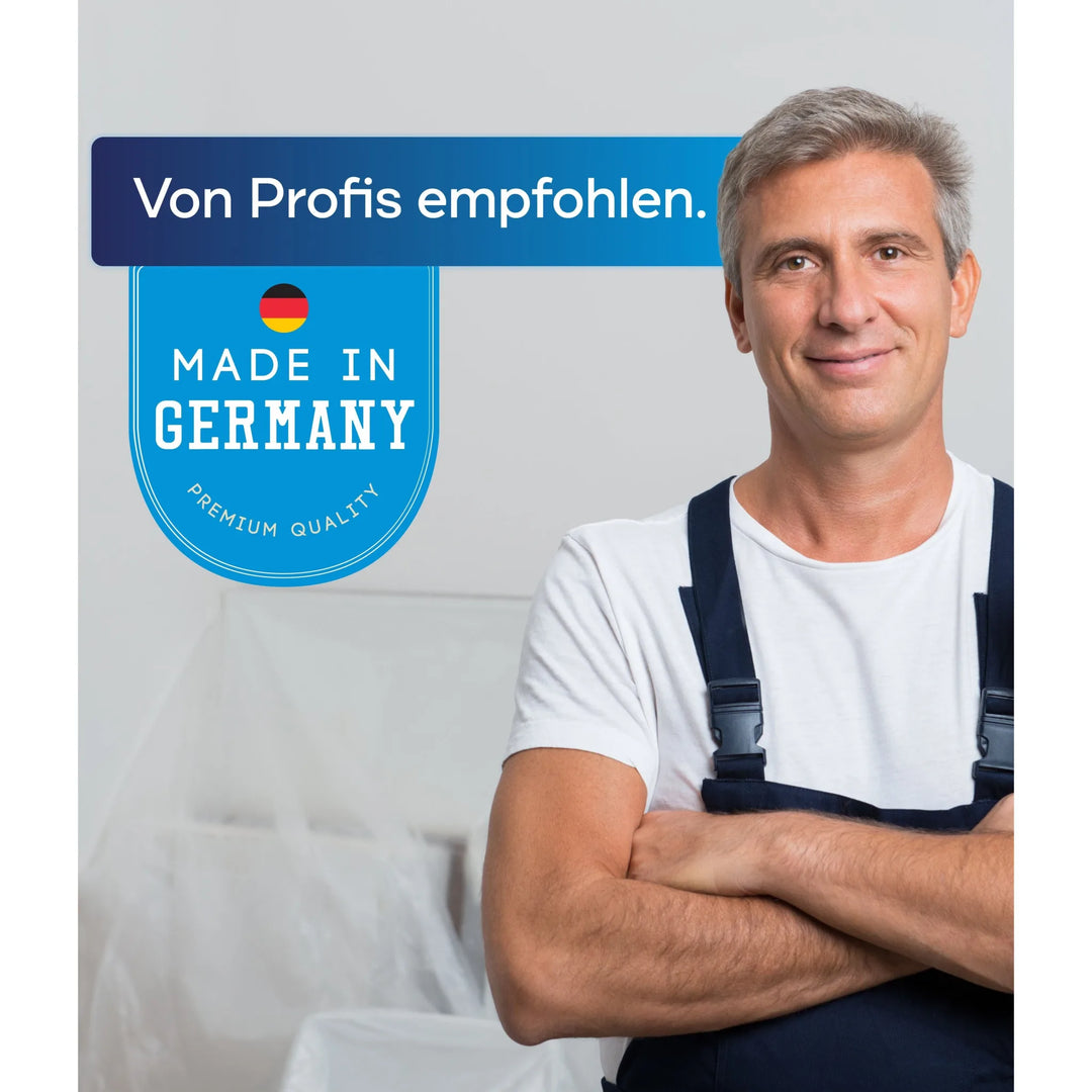 Ein lächelnder Mann in Latzhose steht mit verschränkten Armen neben einem blauen Schild: "Von Profis empfohlen. Made in Germany. Premium Quality" (plid Fassadenfarbe - Anstreichset - Abdeckvlies) - toll für Innenanstriche und Faserzementplatten.