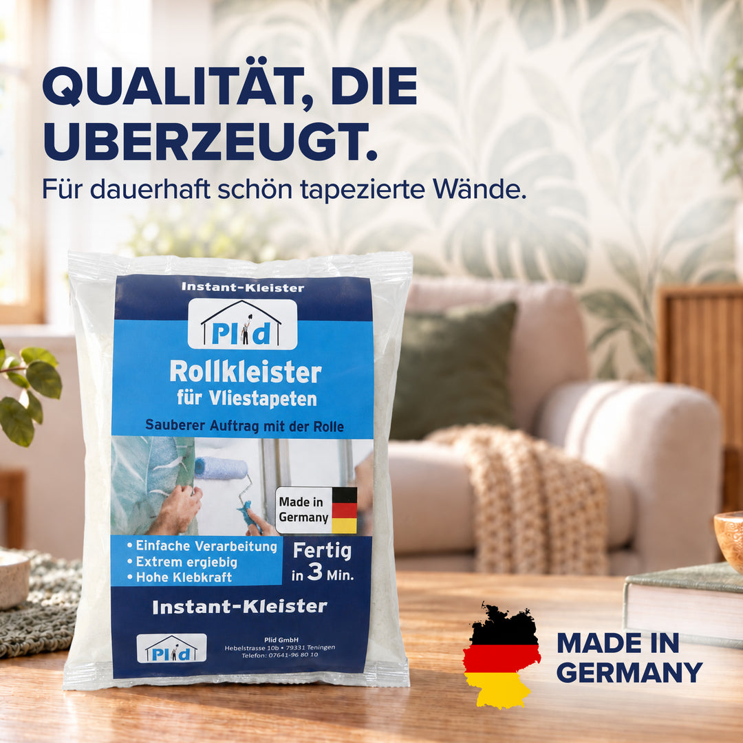 Der Beutel Plid Rollkleister steht auf einem Holztisch in einem hellen Wohnzimmer, im Hintergrund eine tapezierte Wand mit Blattmuster. Das Siegel mit Deutschlandkarte weist auf die Herstellung in Deutschland hin.