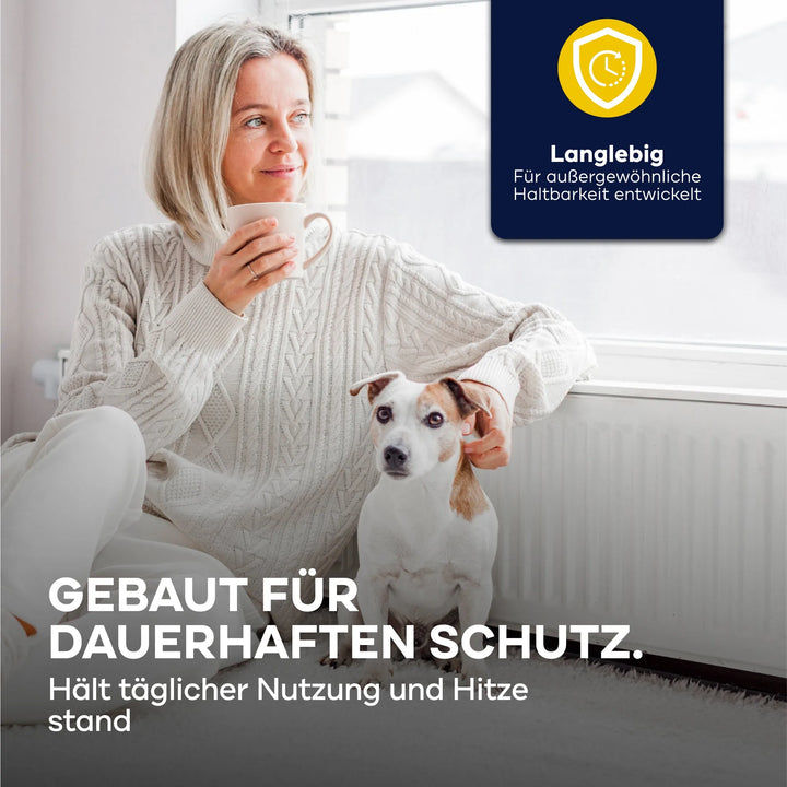 Eine Frau in einem gemütlichen Pullover sitzt mit ihrem Hund am Fenster und hält eine Tasse in der Hand. Deutscher Text wirbt für plid Heizkörperlack LH - Terpentinersatz für dauerhaften Alltagsschutz und Hitzebeständigkeit auf Warmwasserheizungen.