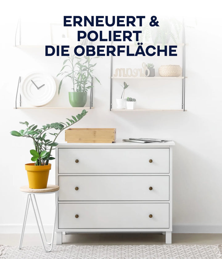 Eine moderne weiße Kommode mit drei Schubladen steht an einer weißen Wand, darunter Regale mit Pflanzen, einer Uhr und Dekoration. Eine kleine Pflanze in einem gelben Topf sitzt auf einem Hocker. Die Oberfläche wurde mit plid Plid Möbellack kratzfest und seidenmatt erneuert.